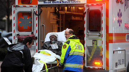 Paramedics take a person who was inside the Roosevelt Arms Building in Downtown Pittsburgh to an ambulance after a fire broke out there on the ninth floor on Thursday.