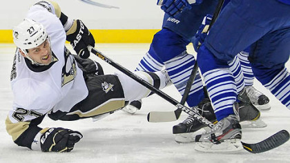 Penguins' Craig Adams battles for a loose puck against the Toronto Maple Leafs.