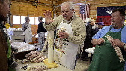 Leon Panella discusses the best way to wrap a sopressata during the traditional sausage-making party in his Prospect garage. The sopressata was being prepared for drying.
