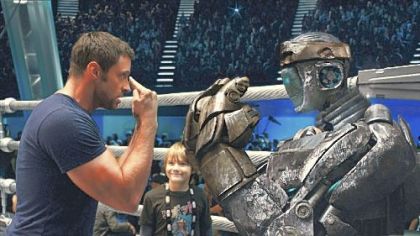 Hugh Jackman gives instructions to Atom while his son, played by Dakota Goyo, looks on in "Real Steel."