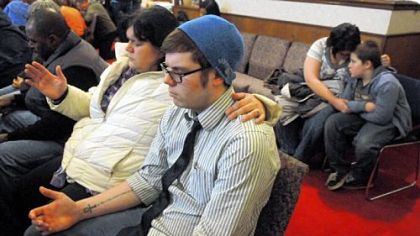 At left, residents gather to pray for the the shooting victims at the Chardon Assembly of God church Monday evening.