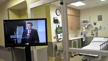 Highmark president and CEO Kenneth Melani speaks by television to those attending the reopening ceremony.