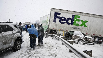 Motorists gather at the scene of a multivehicle crash on Interstate 80 westbound near Harrisville, Venango County. At least three people were killed in the Saturday afternoon crash, which involved about 20 vehicles. Officials said whiteout conditions and slick roads contributed to the crash.