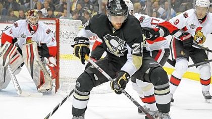 Eric Tangradi, one of the players who has been called on to help fill the void left by the absence of so many injured Penguins, battles for a loose puck against the Senators Tuesday night at Consol Energy Center.