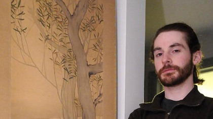 Matt Ketchum, home from Japan for the holidays, brought back memories of his brush with death from the tsunami that devastated coastal regions of the country. He stands with scroll art done by the grandfather of a friend, Seiji Shimoyama.