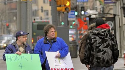 Dave Ninehouser, left, and Henry Lipput pass out literature on Wood Street, Downtown, during a demonstration organized by PA Wants to Work outside Point Park University's Lawrence Hall, where the House Democratic Policy Committee was to hold a heariing about transportation and infrastructure.