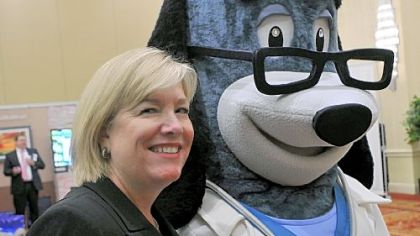 Sue Schick, CEO of United Healthcare of Pennsylvania and Delaware, stands with Dr. Health E. Hound during the UHC health fair at the Wyndham Grand hotel on Tuesday.