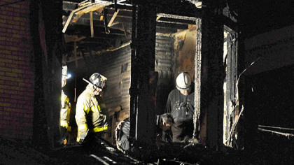 Firefighters investigate the scene at 115 S. Graham St. in Friendship, where a man and a woman were killed in a blaze caused by a 6-year-old playing with a lighter.