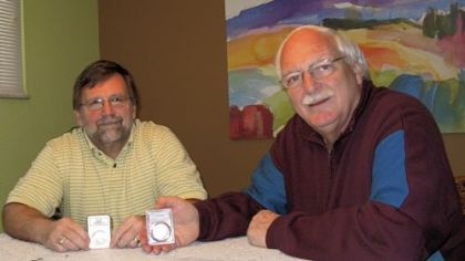 Dale Abel, left, and Richard Gaetano show coins that were encapsulated and graded by a grading service.