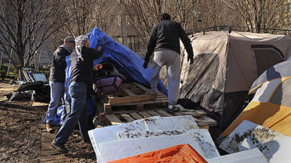 People from the Occupy Pittsburgh movement take down tents at the Mellon Green emcampment.