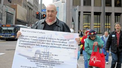 AFL-CIO spokesman Marty Marks, left, leads a group of protesters to Gov. Tom Corbett's local office Downtown on Wednesday.
