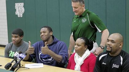 Jamil Pollard gives the thumbs up after signing with Penn State Feb. 1. With him are his parents, Lucille Bevans and James Pollard, at right, Mr. Pollard's son, Brandon Holmes, left, his coach, Clyde Folsom, standing.