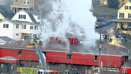 Smoke emanates from Sarris Candies in Canonsburg around 7 a.m. Friday after a fire broke out above the part of the building that houses the ice cream parlor.