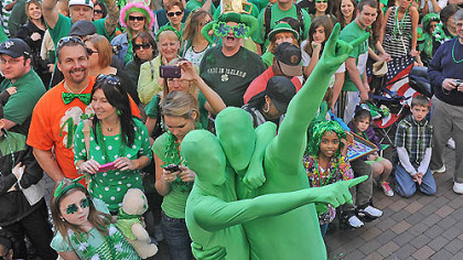 Decked out in green two spectators cheer as the St. Patrick's Day Parade marches by on Grant Street Downtown today.