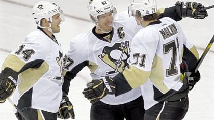 Chris Kunitz, left, and Sidney Crosby celebrate a goal by Evgeni Malkin, right, in the second period Saturday in Newark, N.J. Crosby recorded an assist on the play.