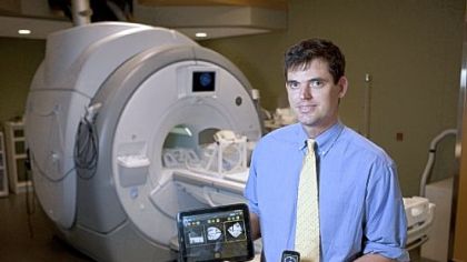 Stanford University research associate Andrew B. Holbrook holds an HP TouchPad Tablet and a Palm Pixi Plus, which contain apps he's developing that allow users to control an MRI scanner.