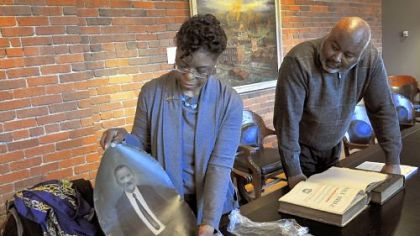 Inez Miles unpacks an old family photograph at the Heinz History Center as curator Samuel Black watches on Monday. Between them is a Miles family Bible from the 1800s. Ms. Miles, the Aurora Reading Club of Pittsburgh's immediate past president and a vice president at the Downtown office of Citizens Bank, knows firsthand that an ancestor's nurturing ways smoothed the path for her birth.