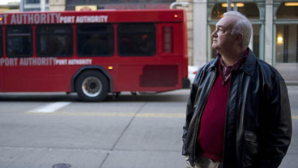 AFL-CIO communications director Marty Marks watches a rally of public transit advocates Downtown.