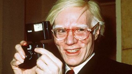 Andy Warhol holds a camera in New York in 1976.