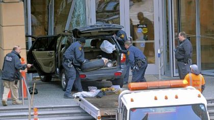 Police check the SUV that careened up the steps of the PNC First Side Center building Downtown today.