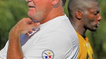 Kevin Colbert, Director of Football Operations for the Pittsburgh Steelers surveys a training camp practice last year while safety Ryan Clark walks by behind him.