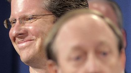 Housing and Urban Development Secretary Shaun Donovan, left, smiles as he listens to Colorado Attorney General John Suthers, right, speak Thursday during a news conference at the Justice Department in Washington, D.C., where a settlement regarding mortgage loan servicing and foreclosure abuse was announced.