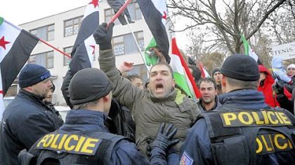 Czech police officers push back a man Sunday as anti-Syrian regime activists call for President Bashar Assad to step down outside the Syrian Embassy in Prague.