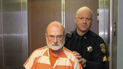 Bridgewater Councilman Gregory S. Hopkins, 65, charged in the 1979 slaying of a Monaca woman, is taken back to jail by a Beaver County sheriff's deputy after his hearing Friday at Beaver County Courthouse.