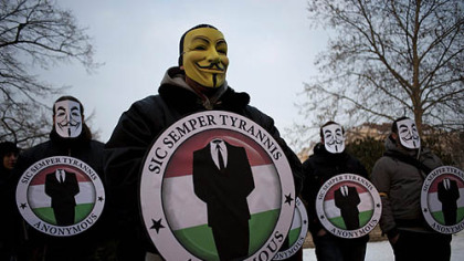 Masked protesters held the logos of the international computer hacker group Anonymous during a demonstration Feb. 11 in Budapest, Hungary. The hacker community was rocked by the news yesterday that one of the world's most-wanted computer vandals has been an FBI informant for months.