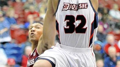 Duquesne's Sean Johnson is fouled on his way to the basket by Massachusetts' Maxie Esho Wednesday.
