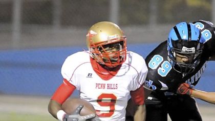 Penn Hills High School's Corey Jones runs for extra yardage against Woodland Hills this past season.