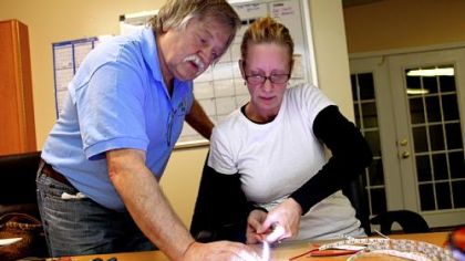 Mr. Prusa shows Cindy Kelly, a member of Peoples Chapel, how to test LED lights the group is sending to Kenya.