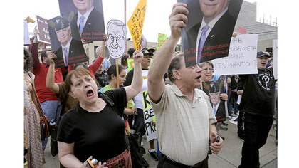 Protesters gather outside the Pittsburgh Opera building in the Strip District to denounce Governor Tom Corbett, who received a lifetime achievement award from the opera.