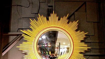 A Dransfield & Ross mirror design for Tozi Home features the bright yellow of No. 2 pencils arrayed in a midcentury starburst design.