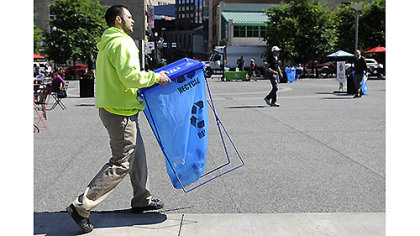 City of Pittsburgh environmental services worker Joseph Cirigliano sets up a trashcan yesterday in Market Square before Mayor Luke Ravenstahl's announcement of the "Don't Trash My Turf!" campaign.