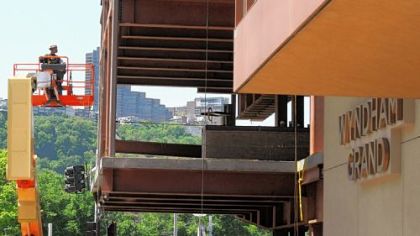 An ironworker on a lift goes to the top of the construction site at the front of the Wyndham Grand, along Commonwealth  Place. The addition could be completed by this August.