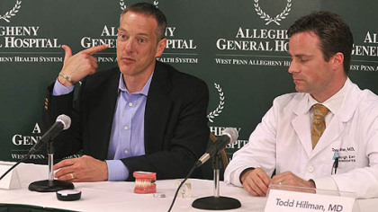 Paul Getsy, of Plum, one of the patients at Allegheny General Hospital using the SoundBite hearing system, describes Tuesday the first sounds he heard after being fitted for the unit as Dr. Todd Hillman listens.