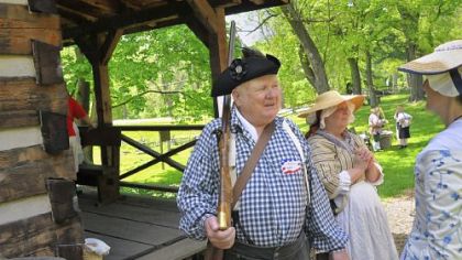 Art Farley, left, portrays James Kiddoo, who owned the grist mill down the road from the Oliver Miller Homestead in South Park. He is standing next to a standard settler's cabin.