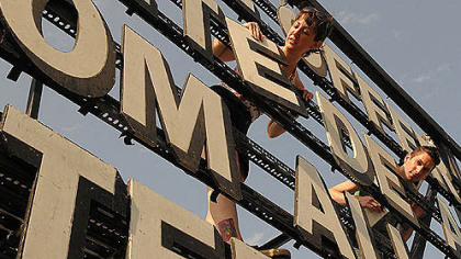 Courtney Ehrlichman and Daniel Lamorte work on changing the billboard in East Liberty.
