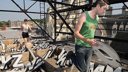 Courtney Ehrlichman and Daniel Lamorte return letters to their boxes after making changes to the billboard atop the Waffle Shop in East Liberty.
