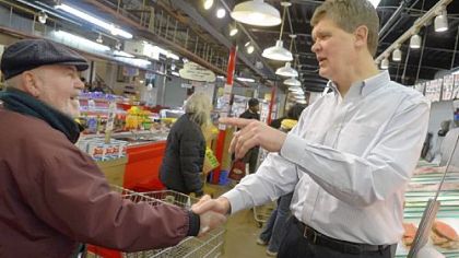 Jim Wholey, right, greets a customer at Wholey's in the Strip District. Jim Wholey is one of four brothers who operate the business, which is celebrating its 100th anniversary.