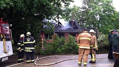 Firefighters survey the scene of a home in Bethel Park where flames broke out early Friday morning.