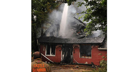Firefighters work on hotspots on the collapsed second floor of a house along Highland Road in Bethel Park where resident Liz Cutone, 83, was killed in an early morning blaze Friday.