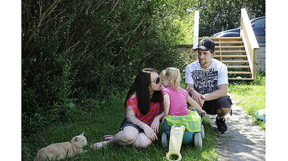 Rachel Bellaire and Jason Stiffler with their daughter, Holland Stiffler, 2, at their home in North Fayette on Wednesday.