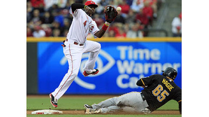 Pirates' Matt Hague steals second base as Reds second baseman Brandon Phillips catches a high throw in the third inning in Cincinnati.