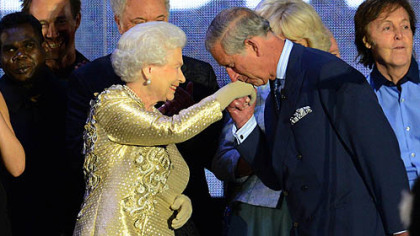 Britain's Prince Charles kisses the hand of his mother, Queen Elizabeth, whom he called "Mummy," on stage Monday as singer Sir Paul McCartney looks on at right after a concert outside Buckingham Palace in London, celebrating the queen's 60 years as monarch.
