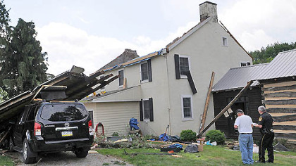 Public safety officials from Westmoreland County survey today the damage to the home of Steve and Tracey Pelesky in Ligonier, where a tornado hit Friday afternoon.