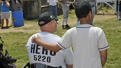 Josiah Vaughn, 10, of Crafton Heights comforts Clairton police officer James Kuzak as he is honored at the first Heroes Game.