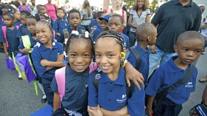Second-graders Nicole Hurt, left, and Aliya Holmes enjoy their first day of school at William F. Harrity Elementary School in Philadelphia. Harrity is one of three failing schools that has been taken over by Mastery Charter Schools.