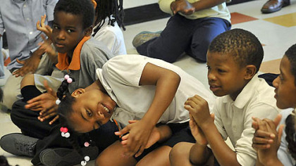 Makita Carter, center, and other students clap during a morning meeting of third-graders in May at Faison K-5 in Homewood.